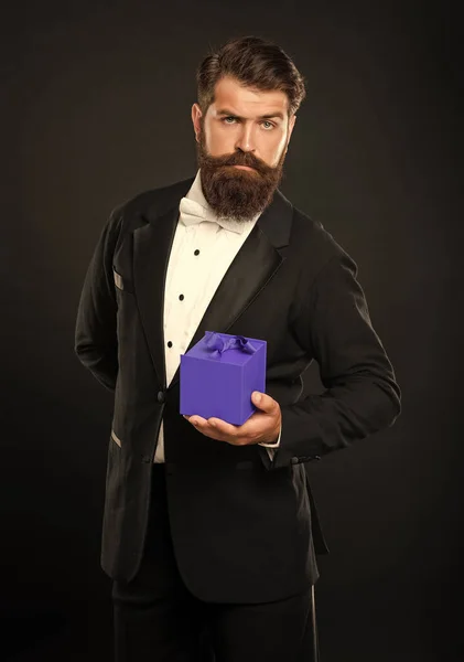 タキシードの弓のネクタイ姿の男が黒の背景に箱をつけて バレンタインデー — ストック写真