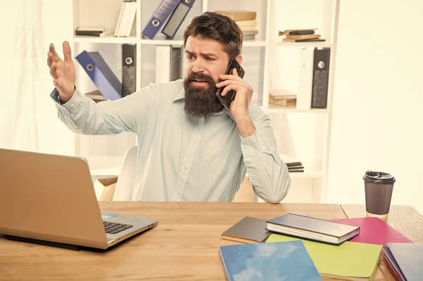 Stressed lawyer yelling on mobile phone working on laptop in office, stress.