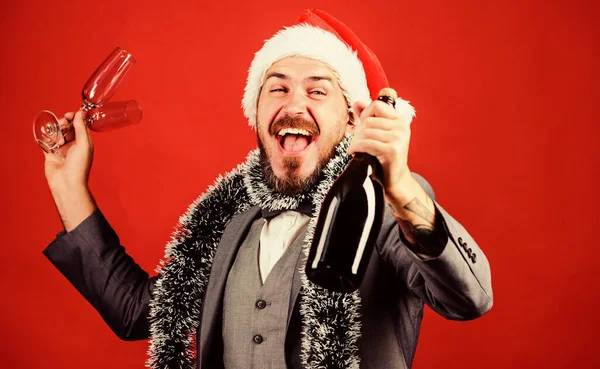 Corporate christmas party. Creative toast. Cheers concept. Join office party. Celebrate new year. Christmas party. Corporate party ideas. Man bearded hipster wear santa hat hold champagne bottle.