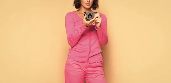 女摄影师带着照相相机手持米色背景 — 图库照片