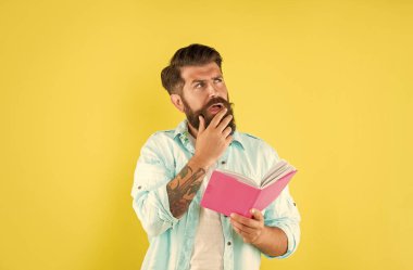 Sarı arka planda planlayıcısı olan düşünceli sakallı adam..
