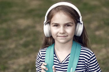 İngilizce öğrenmek içindir. Küçük çocuk kulaklık takıyor. İngilizce okulu. Dil eğitimi. Dinleme becerileri. Yeni teknoloji. Özel ders. Çevrimiçi kurslar. Dinleyip, kopyalayarak İngilizce öğren.