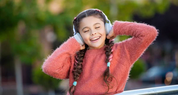 幸せな10代の若者は音楽を聞くことを楽しむ 目を閉じてヘッドフォンを聴く少女10代 Melomaniacティーネージャーリスニング曲屋外 — ストック写真