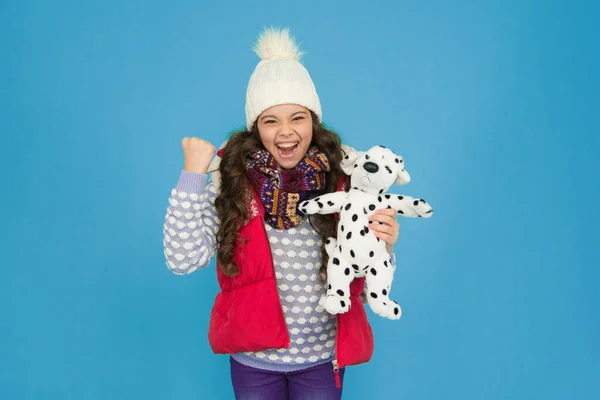 Lovely baby smiling face. Pets shop. Her favourite toy. Happy child hold soft toy. Little girl smile with toy dog. Dreaming about real dog. Kids toy shop or store. Winter style. Childhood fun.