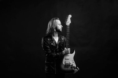 Rock müzik stili yıldızı. müzisyen gitarist. Rock müziğini ustaca çalmak. Modaya uygun çılgın adam. müzik enstrümanı. Deri ceketli sakallı rockçı. Uzun saçlı adam elektro gitar çalıyor..