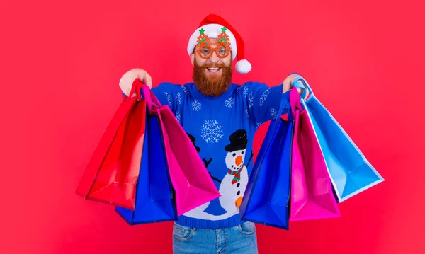 クリスマス ショッピング セール Xmas販売後の買い物袋を持った陽気な男 サンタさんXmasショッピングバッグ付き販売で隔離された赤 — ストック写真