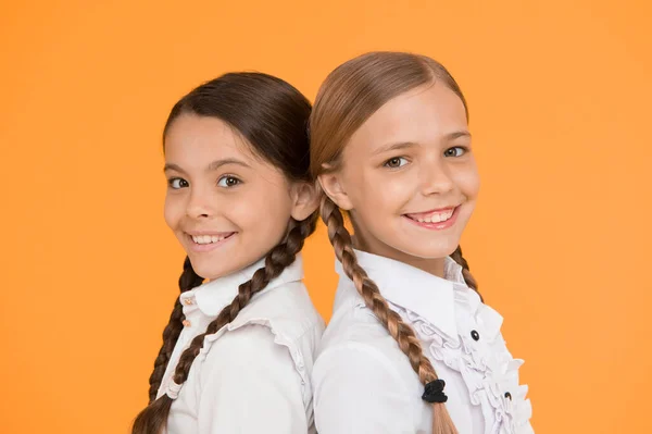 賢くて賢い子供のフォーマルなファッション 海外教育 スマートに見える子供たち 学校の友人 制服を着た幸せな子供たち 黄色の背景に小さな女の子 友情と姉妹関係 親友たちです — ストック写真