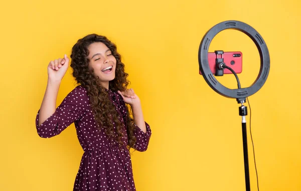 stock image happy child have fun with long curly hair making video for blog.