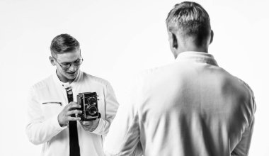 Kendine güvenen genç kardeşler. Kendine güvenen bir fotoğrafçı. Beyazlı ikiz kardeş. Fotoğrafçılık. Güzellik ve moda. Benzer görünüş. Erkek arkadaşlığı. Erkek arkadaş. Retro fotoğraf makinesi olan iki kuzen..