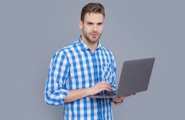 Serbest çalışan serbest çalışmak için dizüstü bilgisayar kullanıyor. Dizüstü bilgisayar kullanan ciddi bir adam. Gri renkte dizüstü bilgisayar sörfü yapan internet stüdyosu.