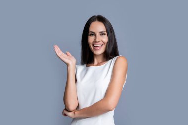 Resmi giyinmiş mutlu bir kadın. Stüdyo resmi. Zarif kadınlar resmi kıyafetler giyer. Gri arkaplanda izole edilmiş resmi kadın portresi.