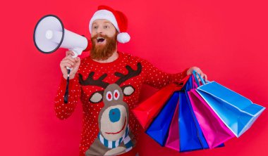 Mutlu noeller. Mutlu adam hoparlörde noel satışları hakkında anons yapıyor. Noel 'de alışveriş çantalı bir adam kırmızıda izole edilmiş..