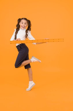 Ders vermek için acelesi var. Enerjik okul çocuğu ders çizmek için uzun cetvel tutan. Matematik ve geometri dersine hazırlanan küçük kız. Okul dersinde ölçme aleti kullanma.