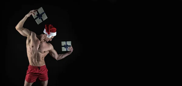 Noel Baba Şapkalı Kaslı Sporcu Hediyesini Tutuyor Siyah Arka Planda — Stok fotoğraf