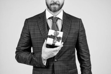 Kırpılmış iş adamı hediye kutusunu tutuyor. Tatil hazırlığı. Hediyelik eşya dükkanı. Hediye fikri. Doğum günü yıldönümü. İndirim ve indirim. Kara Cuma. Siber Pazartesi. Yeni alışveriş deneyimleri keşfet.