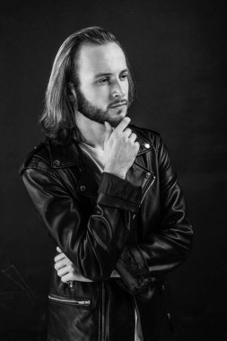 Rock tarzı. Havalı, vahşi hippi adam. Erkek modası. Sakal ve yüz bakımı. Vahşet ve erkeklik. Berber dükkanı. Motorcu. Deri ceketli düşünceli sakallı rockçı. Uzun saçlı adam..