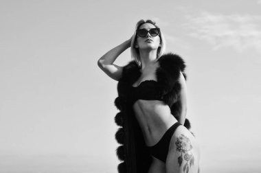 Çekici kadın seksi vücudu. Riskli, cüretkar ve müsrif. Seksi kadın erotik iç çamaşırı kürkü. Zenginlik lüksü ve şık bir konsept. Yaz modası. Dövmeli seksi kız. Gökyüzünde seksi bir kız..