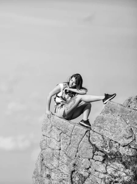 観光客のハイカーの女の子のエッジ崖のリラックス 危険なリラックス 極端な概念 世界の果てだ 女性の崖の端に高い山の青空の背景に座っている 平和な瞬間をハイキング 景色を楽しむ — ストック写真