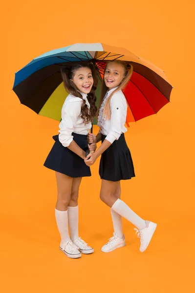 二人のための場所だ ファッションアクセサリー 傘を持っている女の子の友人 雨の日 幸せな子供時代 学校の時間だ レインボー傘 カラフルな人生だ 女子高生は傘がうれしい 秋の天気予報 — ストック写真