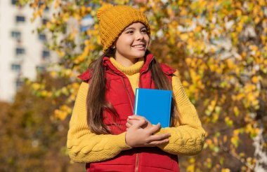 Sonbaharda neşeli kız öğrenci okula geri dönüyor..