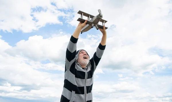 フリーシニア引退した男 定年退職した男だ おもちゃの飛行機の屋外で空の背景の老人 — ストック写真