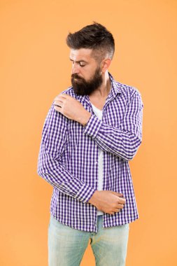 Tamamen kusurlu. Moda cılız, sarı arka plandaki kollarından lekeler ilerler. Hipster tarzında sakallı adam. Rahat moda kıyafeti giyen uzun sakallı trendy hipster. Moda trendi.