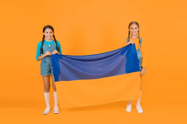 Patriotism respect and love to motherland. National identity concept. Ukrainian kids. Girls with blue and yellow flag. Patriotic education. Happy independence day. Children hold ukrainian flag.