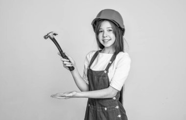 Ürün sunumu. Gri arka planda mühendis. İşçi çocuk şapka takıyor. İşçi bayramı. Üniformalı ve kasklı genç kız. Sert şapkalı kadın müteahhit. Bina ve inşaat. çocuk mimar işçi.