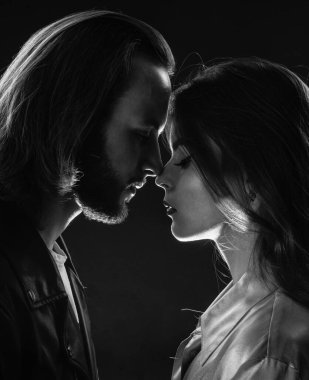 İlişkilerde sorunlar. Aşk ve romantizm. Romantik ilişki. Sevgili olarak. Öpücük. Birbirine aşık çiftler. Modaya uygun bir çift portresi. Uzun sakallı, uzun saçlı adam, kadını öpüyor..