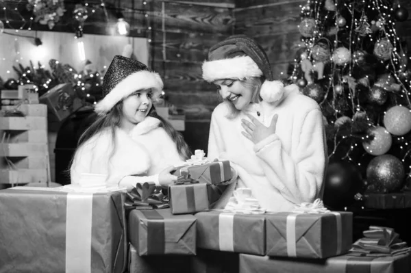 冬休みだ 女の子への贈り物 ギフトボックス付きのお母さんと子供 娘には驚きだ 幸せな休日 家族への贈り物の準備 新年の伝統 ボクシングの日だ クリスマスツリーの近くにギフトを包んだ — ストック写真