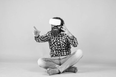 Yeni gerçeklik burada. Mutlu gelecek. Adam kablosuz internet gözlüğü takıyor. VR kulaklıklı adam. Sakallı hippi modern teknoloji kullanır. Dijital gelecek ve yenilik. Sanal gerçeklik gözlüğü takan acımasız bir adam..