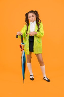 Sonbahar yağmuru. Okula gidiyorum. Yağmur geçirmez kıyafetler. Yağmur bitti. Yağmur yağıyor. Yağmurlu günleri bekliyorum. Şemsiye ile Schoolgirl şık küçük çocuk su geçirmez yağmurluk giymek. Suya dayanıklı giysiler.