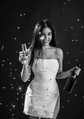 Cazibeli kadın konfeti altında eğleniyor. Seksi kadın şampanya ve bardak içer. Kadın parti kutlaması. Güzel bayan doğum gününü kutluyor. Formalite içinde genç bir kız..