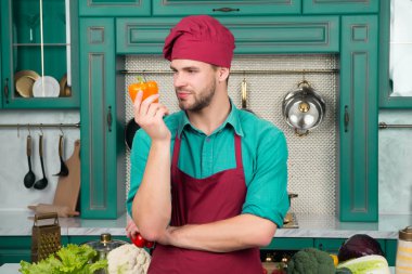 Kırmızı şapkalı, turuncu biber sebze mutfak önlük göz maço Şef. Vejetaryen, sağlık, diyet kavramı. Yemek, yemek, mutfak, mutfak.