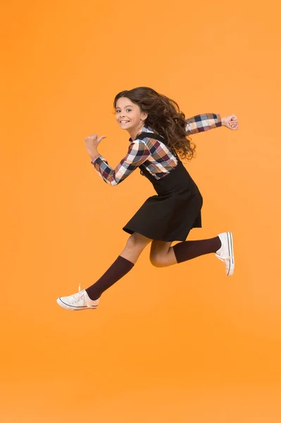 Break into. Feel inner energy. Girl with long hair jumping on yellow background. Carefree kid summer holiday. Time for fun. Active girl feel freedom. Fun and jump. Happy childrens day. Jump concept.