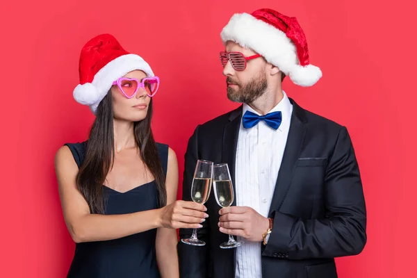 cheers. christmas couple celebrate party isolated on red. celebrate christmas party with couple. merry christmas to couple at party in studio. couple celebrate christmas. lets celebrate holiday party.