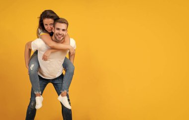 Mutlu romantik çift sırtıma binip eğleniyor Sarı arka plan fotokopi alanı, aşkım.