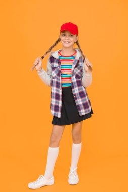 Rahat bir kıyafet. Modern kıyafet. İsyan eden ergen. Sokak tarzı. Havalı liseli. Sarı arka plandaki karizmatik kızda iyi eğlenceler. Tomboy konsepti. Gençlik çağında. Sevimli kız şık giyimli genç kız.