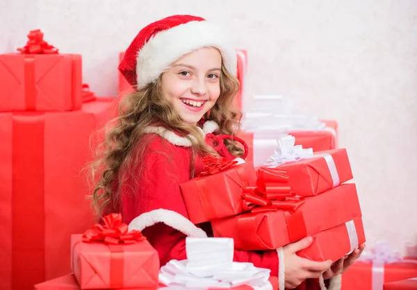 クリスマスのギフトを探検しなさい クリスマスプレゼントを 子供はクリスマスプレゼントを開くことに興奮しました 女の子はクリスマスを祝う 子供がサンタを助けてる お正月の伝統 小さなサンタヘルパーコンセプト ロイヤリティフリーのストック画像