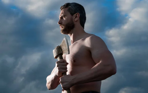 stock image shirtless man with axe. brutal caucasian man hold ax. brutal man on sky background.