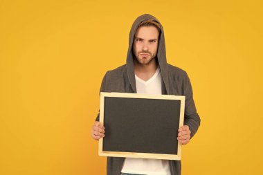 Adam duyuru yapıyor. Kara tahtanın arkasındaki erkek. Yararlı bilgi için yer. Reklam fotokopisi. Pazarlama tasarımın. Kapüşonlu ve tahtalı adam..