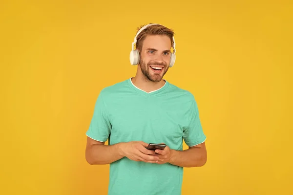 Ευτυχισμένος Νεαρός Άνδρας Πράσινο Μπλουζάκι Ακούγοντας Μουσική Στο Κινητό Τηλέφωνο — Φωτογραφία Αρχείου