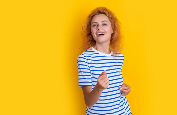 redhead woman dance isolated on yellow background. portrait of young redhead woman in studio. adult redhead woman portrait.