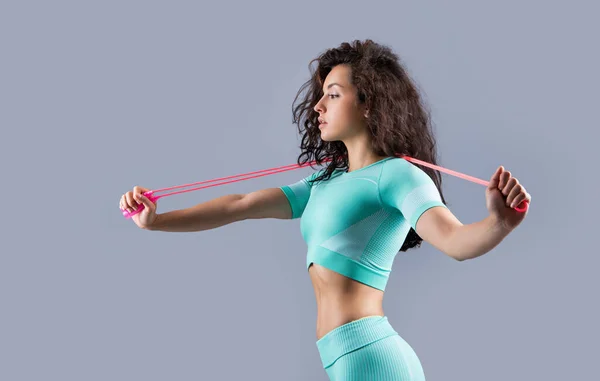 fit fitness woman in sportswear with skipping rope at studio. fitness woman in sportswear hold skipping rope isolated on grey background. fitness and sport.