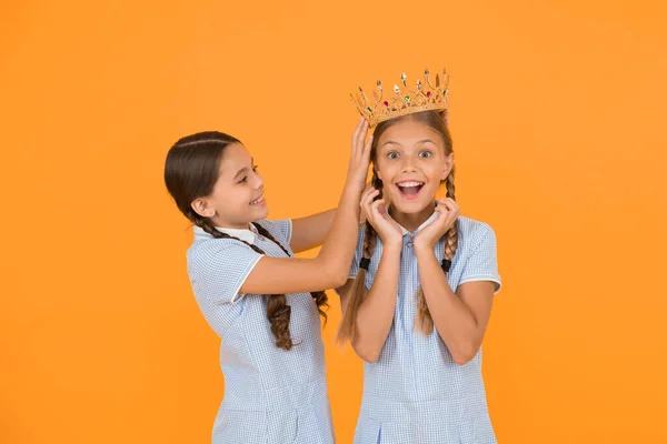higher standard. vintage girls in gold crown. motivation to be the best. small egoist girls imagine they princess. success reward. happy childhood frienship. prom queen. retro look of selfish kids.