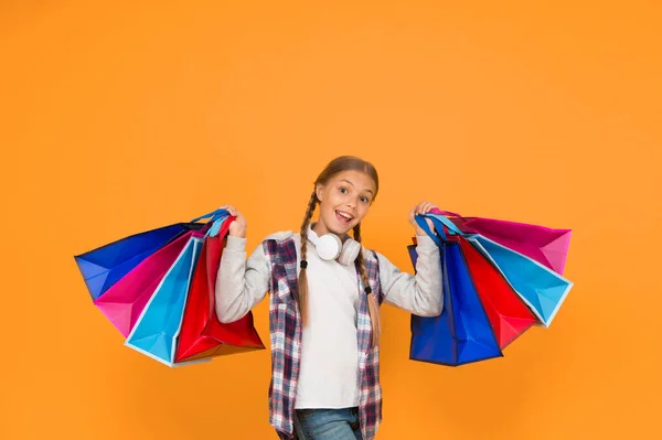 准备和庆祝假日 在黑色星期五购物和销售 上瘾的消费者 沉迷于购物 带着纸袋的快乐孩子 小女孩带着黄色背景的购物袋微笑 — 图库照片