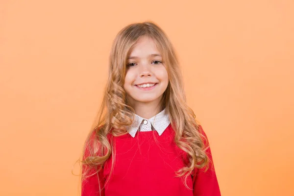 快乐的童年概念 可爱的脸上带着微笑的女孩 橙色背景的金色卷发孩子 — 图库照片