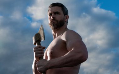 Baltalı üstsüz adam. Oduncu adam baltayı tut. Gökyüzündeki vahşi adam.