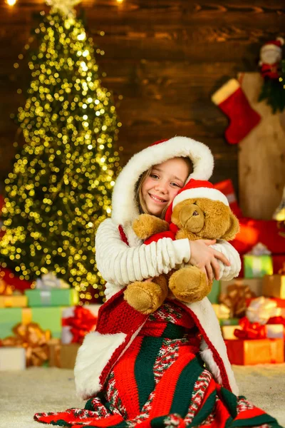 Best wishes. morning before Xmas. Cute little girl with gifts. Kid enjoy the holiday. winter holiday and vacation. Portrait kid with gift. free time and joy. kid in santa costume at christmas present.