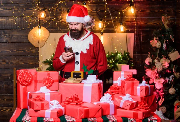 新年の新技術です 新年明けましておめでとう 冬のショッピング販売 親戚にSmsを書く クリスマスプレゼントだ 髭の男サンタ 親戚への挨拶 髭を生やしたサンタは住所で贈り物を届け — ストック写真